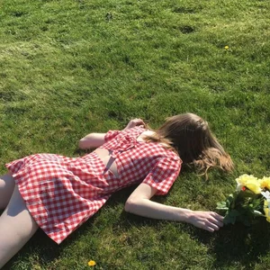 Skinny Girl in Chequered Dress Lying on the Grads Photo