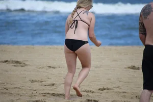 Chunky blonde in a black bikini on the beach