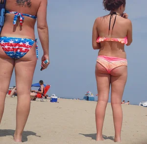 Trio of girls in bikinis on the beach and one with an incredible ass