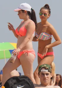 Two sexy girls in peach and pink bikinis on the beach