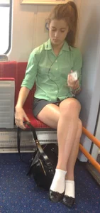 Cute Girl in Shorts Sitting in the Train with Crossed Legs Candid Photo