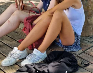 Girl in a Skirt With Nice And Skinny Legs Sitting on the Pavement, Her Panties Flashing
