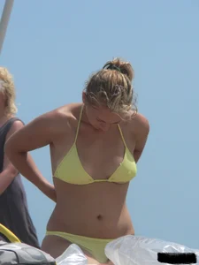 Sexy blonde on the beach in a yellow thong bikini