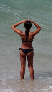 Black girl on the beach in a bikini with an incredible ass while surfing