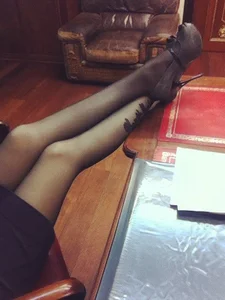 Girl on High Heels in Black Pantyhose and Skirt with Her Legs on the Table Office Candid
