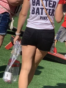 Bunch of girls in various outfits at a Cardinals baseball game