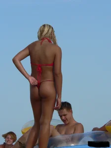 Sexy mom and daughter in red thongs at the beach