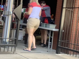 Bunch of girls in various outfits at a Cardinals baseball game