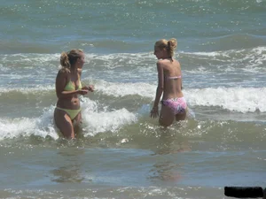 Sexy blonde on the beach in a yellow thong bikini