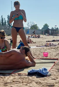 Sexy blonde milf on the beach in blue thong bikini and showing nice camel toe