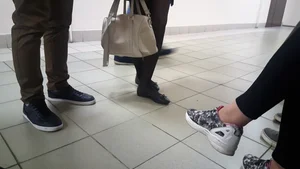 Thin Legs of a Candid Girl in a Skirt And Black Pantyhose in a College Corridor