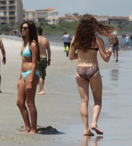 Brunette and redhead on the beach in bikinis looking sexy