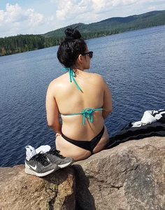 Thick brunette at the lake in a black thong bikini