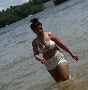 Big boobed brunette on the beach in white bikini