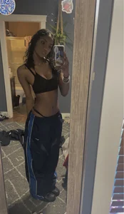A Hot Slim Girl in a Top And Loose Sweatpants Home Mirror Selfie