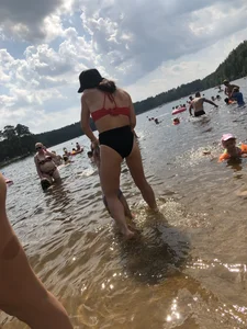 Milf in a Swimsuit Playing in Water on a Beach
