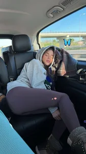 Cute girl in leggings and a hoodie fell asleep on the car back seat creepshot