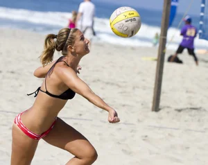 Hot girls playing beach volleyball in bikinis and shorts