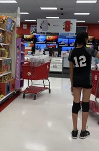 A Very Skinny Girl in Shorts and Knee Pads at the Supermarket Candid Photo