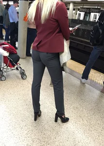Blonde in tight dress pants waits for the train