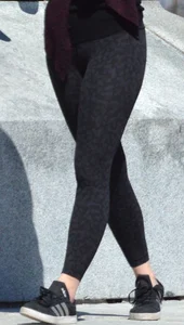 Brunette with glasses on the phone in tight patterned leggings