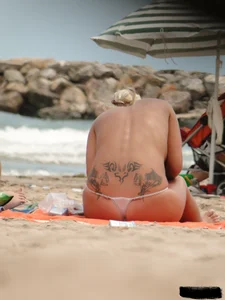 Tattooed blonde with big tits topless and in thong