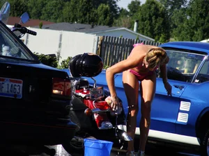 Group of cute girls at a car wash in bikinis and shorts