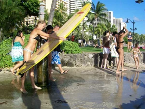 Skinny blonde surfer on the beach in little bikini