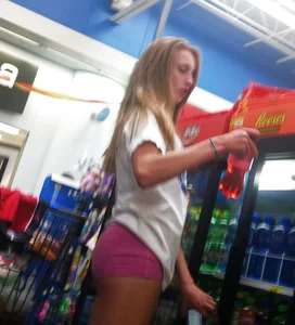 Teen blonde candid hottie in pink mini shorts at the store creepshots