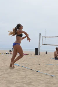 Sexy beach volleyball girl in sport bra top with pokies and blue bikini bottom