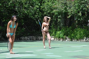Two sexy girls playing tennis in bikinis