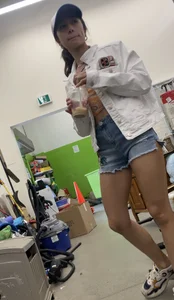 Tight bum hanging out of jean shorts in thrift shop
