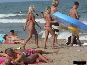 Sexy mom and daughter in red thongs at the beach