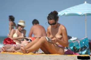 2 topless girls at the beach in thongs