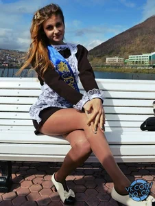 Hot Teen in Uniform Sitting on Bench Cross-Legged in Short Dress