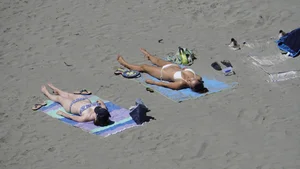 Sexy beach girl laying out in white bikini with nice body