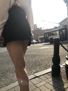 Awesome candid chick wearing a blouse and a skirt crossing the street on high heels, showing a little cheek