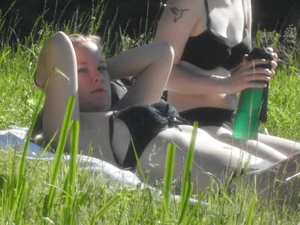 Two sexy friends in black bikinis laying out