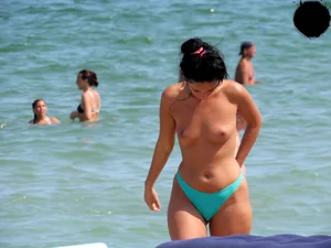 Brunette topless babe with cute tits and a nice ass in a thong bikini