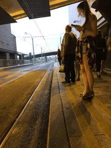 Cute Teen in Shorts on the Tram Stop