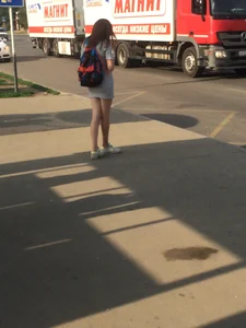 Skinny Girl in Short Striped Dress on a Bus Stop