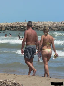 Sexy blonde on the beach in a yellow thong bikini