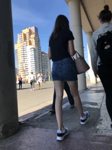 Cute Girl in a Short Denim Skirt Walking on a Street And Waiting on a Crosswalk Gallery