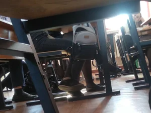 Teen Girl’s Legs in Jeans Under Desk in a Classroom Photo