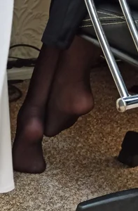 Cute Candid Feet in Black Pantyhose Under an Office Desk Closeup Photo