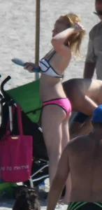 Skinny blonde girl on the beach in her pink and white bikini