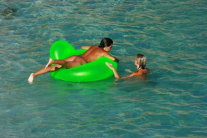 FKK Nudists playing in the water with floater