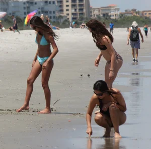 Brunette and redhead on the beach in bikinis looking sexy