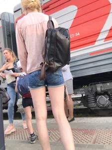 Candid with long thin legs wearing denim shorts waiting to get on a train