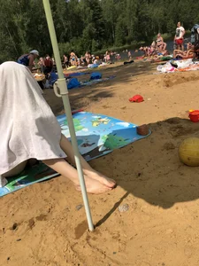 Skinny Girl Sitting Under a Towel at a Beach Photos